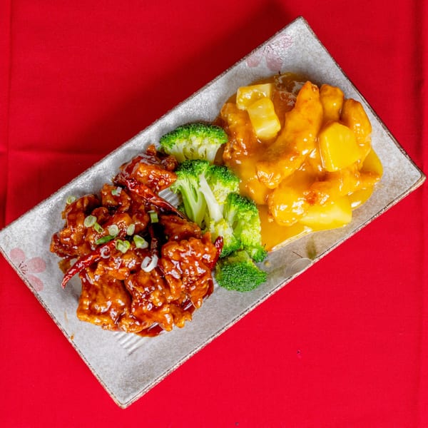 Sweet and sour chicken, General Tso's chicken, and broccoli on a rectangular plate.