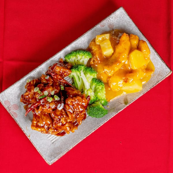 Sweet and sour chicken with pineapple, General Tso's chicken, and broccoli on a rectangular plate.